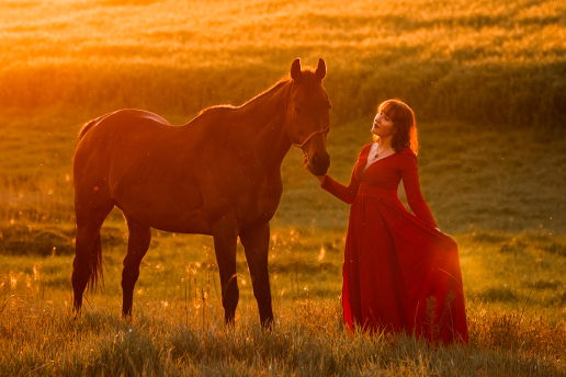 Dziewczyna z białek bluzce z wiankiem na włosach trzyma jasnego konia